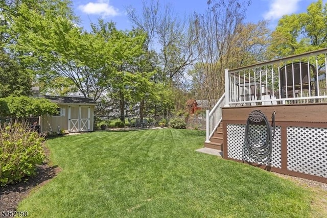 view of yard with an outdoor structure, a shed, a deck, and fence