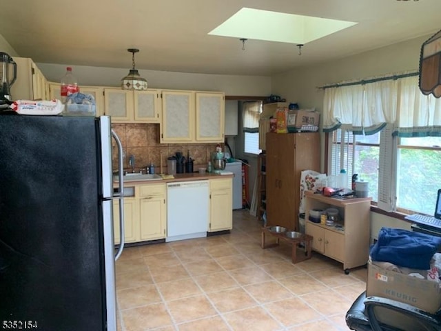 445 E Cape May, Ocean Gate Boro, NJ 08740 - kitchen with freestanding refrigerator, white dishwasher, backsplash, cream cabinetry, and light tile patterned floors