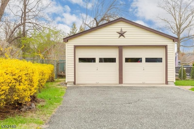detached garage featuring fence
