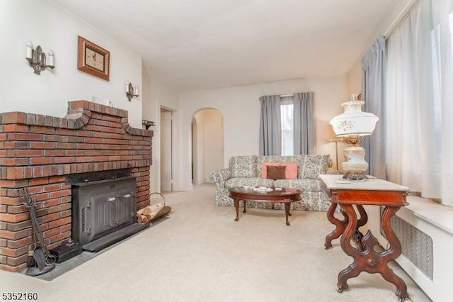 carpeted living area featuring arched walkways