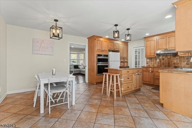 19 Tunnell Rd, Franklin Twp, NJ 08873 - kitchen with double oven, under cabinet range hood, freestanding refrigerator, a kitchen island, and decorative backsplash