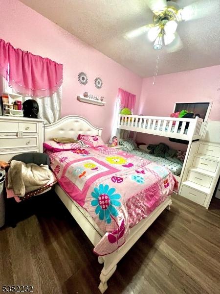 bedroom featuring wood finished floors, a textured ceiling, and a ceiling fan