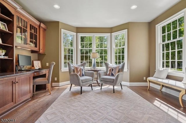 sitting room with baseboards, light wood finished floors, a desk, and recessed lighting
