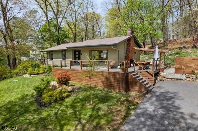 ranch-style home with a chimney, a front lawn, and stairway