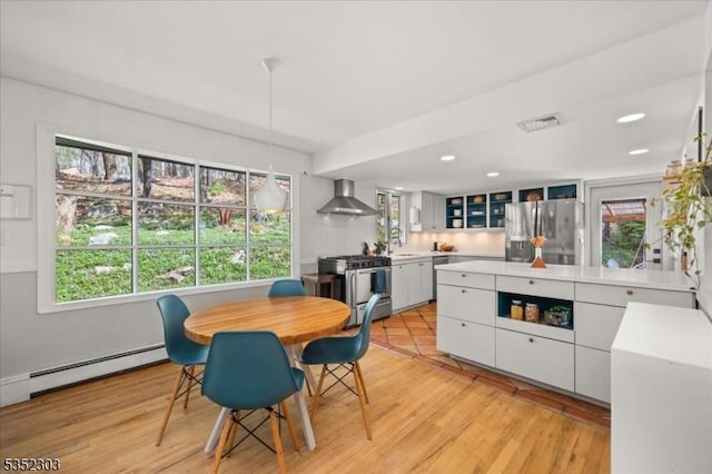 dining room with a baseboard heating unit, recessed lighting, light wood-style flooring, and visible vents