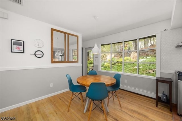 dining area featuring baseboard heating, baseboards, and wood finished floors