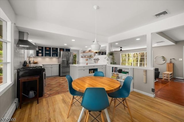 dining space featuring visible vents, recessed lighting, light wood-style floors, and a baseboard heating unit
