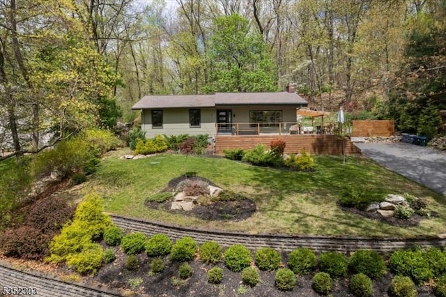 ranch-style house with a chimney and a front yard