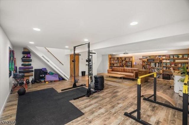 exercise area featuring recessed lighting, baseboards, and wood finished floors