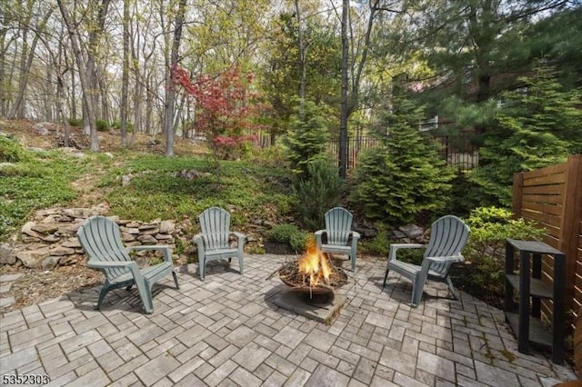 view of patio / terrace featuring fence and a fire pit