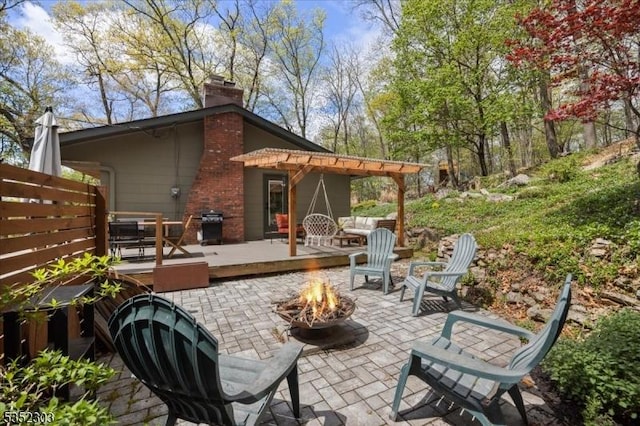 view of patio / terrace featuring an outdoor fire pit, a wooden deck, and grilling area