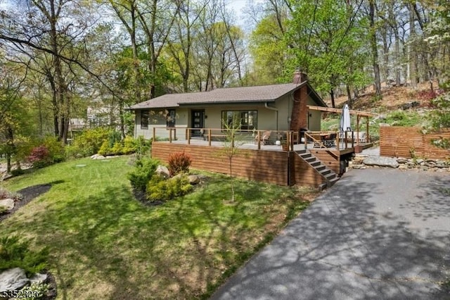view of front of house with a front lawn, stucco siding, and a chimney