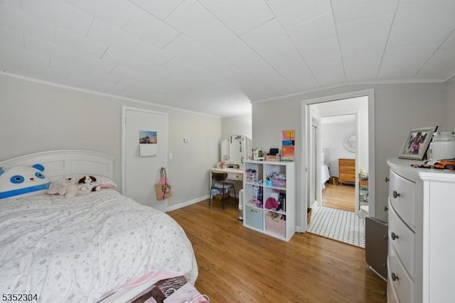 bedroom featuring ornamental molding and wood finished floors