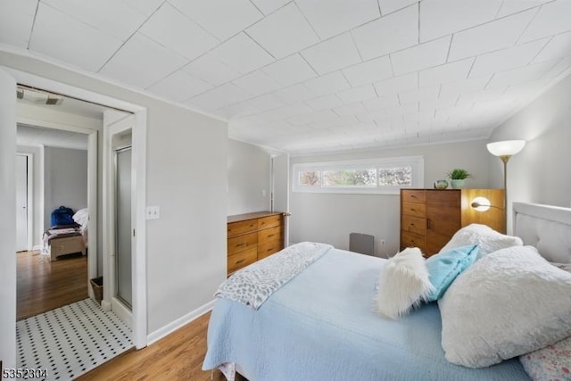 bedroom featuring light wood-type flooring, baseboards, crown molding, and visible vents