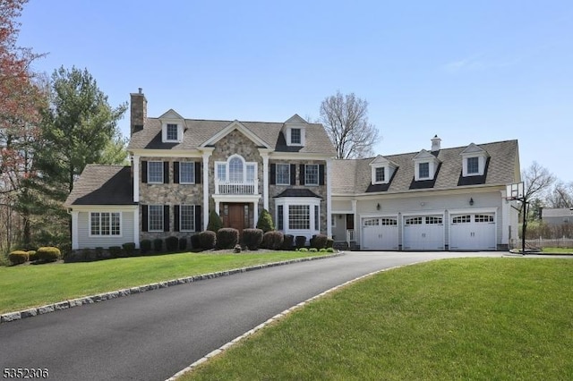 82 Queen Anne Dr, Bernards Twp, NJ 07920 - view of front of house with a front lawn, driveway, stone siding, a chimney, and an attached garage