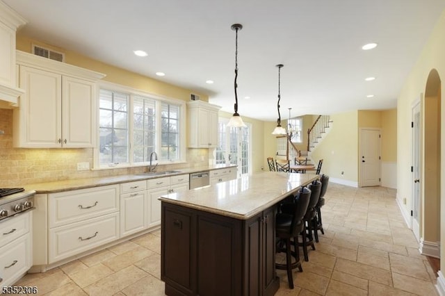 82 Queen Anne Dr, Bernards Twp, NJ 07920 - kitchen featuring stone tile flooring, a sink, recessed lighting, a kitchen bar, and backsplash