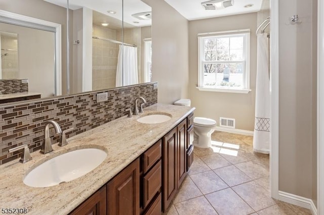 bathroom featuring baseboards, visible vents, and a sink