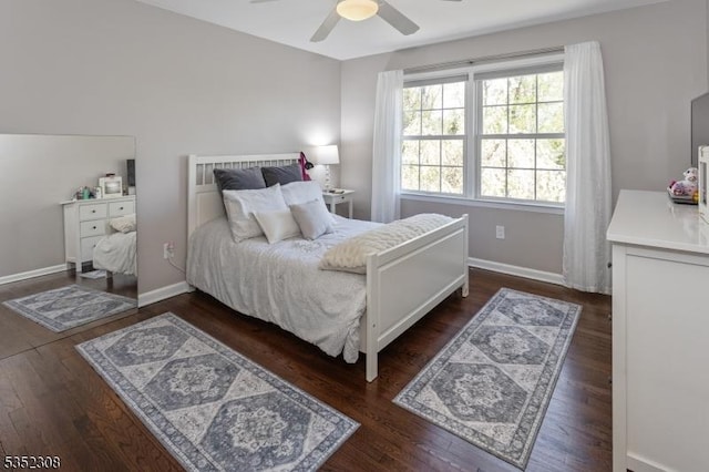 bedroom with a ceiling fan, baseboards, and dark wood-style floors