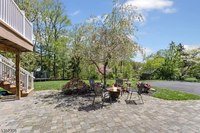 view of patio / terrace featuring a trampoline, an outdoor fire pit, and stairway