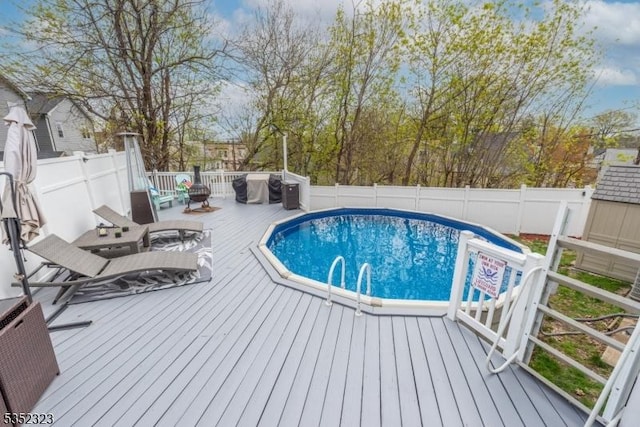 view of pool with a wooden deck, a fenced in pool, and a fenced backyard