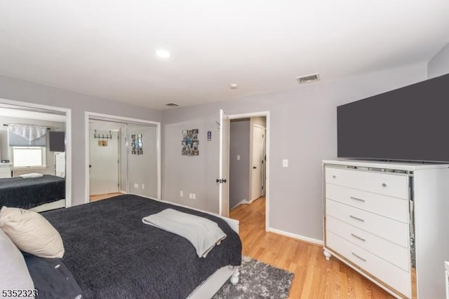bedroom featuring visible vents, baseboards, and light wood-style floors