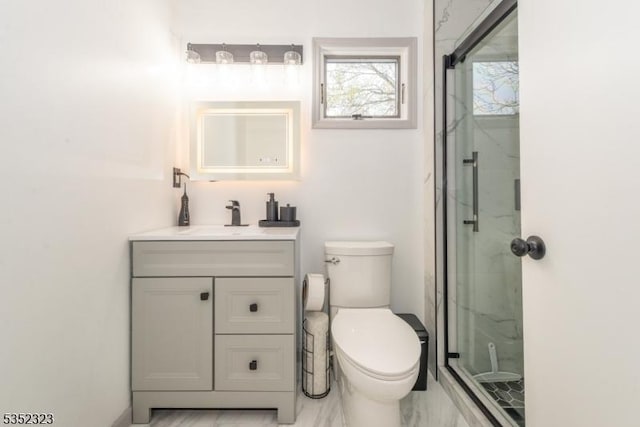 full bath featuring toilet, a marble finish shower, marble finish floor, and vanity