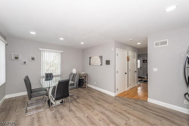 dining space with baseboards, visible vents, light wood-type flooring, and recessed lighting
