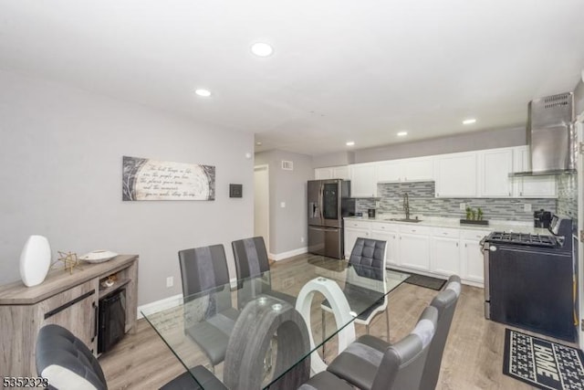 dining room featuring baseboards, recessed lighting, and light wood-style flooring