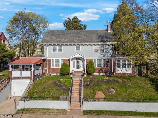 colonial home featuring a front yard, a garage, a fenced front yard, stairs, and brick siding