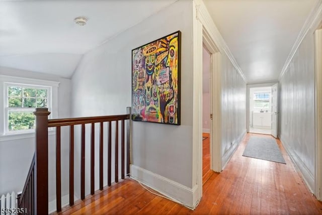 hallway with hardwood / wood-style floors, a wealth of natural light, an upstairs landing, and vaulted ceiling