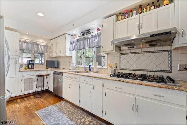 kitchen featuring a sink, white cabinetry, stainless steel appliances, and under cabinet range hood