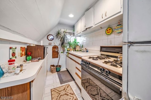 kitchen with white appliances, light floors, light countertops, white cabinets, and vaulted ceiling