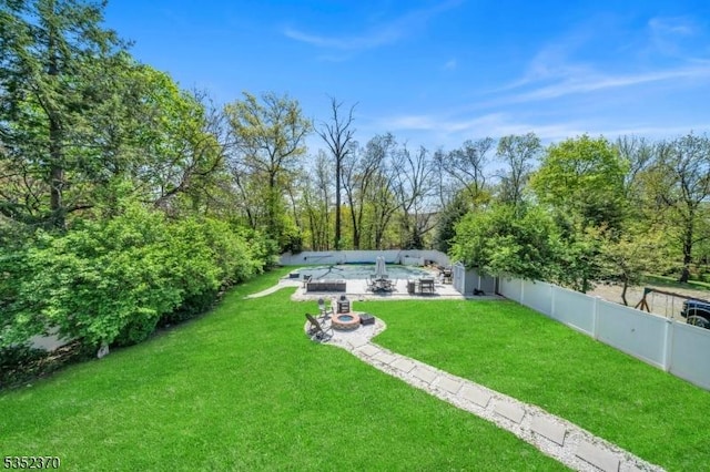 view of yard featuring a fenced backyard, a fire pit, and a patio area