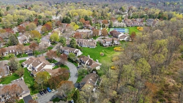 aerial view of property's location featuring nearby suburban area and a forest