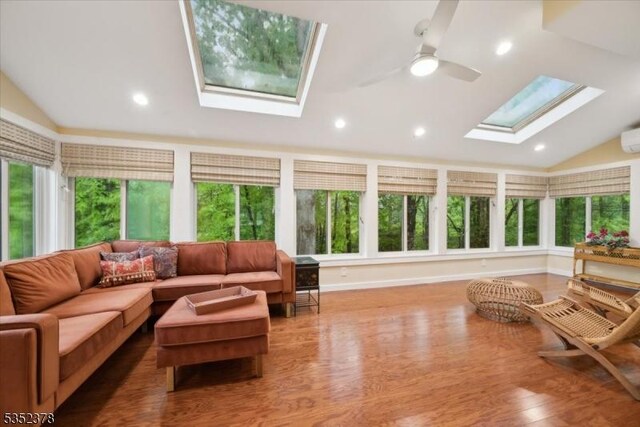 sunroom with a skylight, vaulted ceiling, plenty of natural light, wood finished floors, and recessed lighting