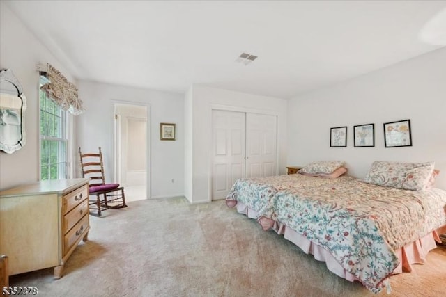 bedroom with a closet and light carpet
