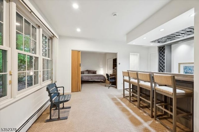 carpeted bedroom featuring baseboard heating, recessed lighting, baseboards, and a dry bar