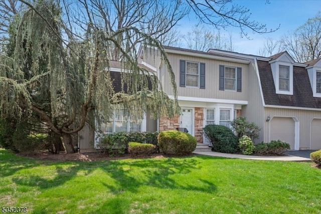 view of front of property featuring a front lawn, a garage, stone siding, and a shingled roof