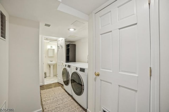laundry area featuring a sink, baseboards, laundry area, and washer and dryer