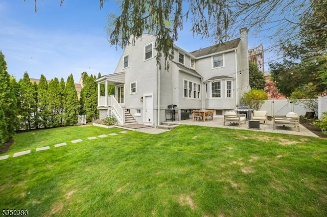 back of property featuring fence, stucco siding, a gate, a patio, and a yard