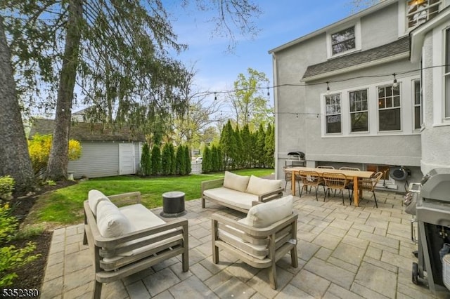 view of patio with area for grilling, an outdoor structure, an outdoor living space, and outdoor dining space