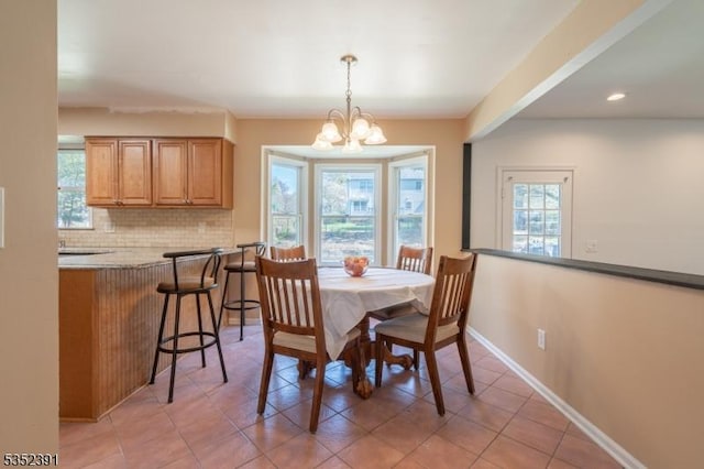 dining room featuring light tile patterned flooring, recessed lighting, a notable chandelier, and baseboards
