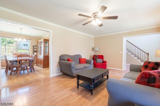 living room featuring stairway, light wood-style floors, crown molding, and baseboards