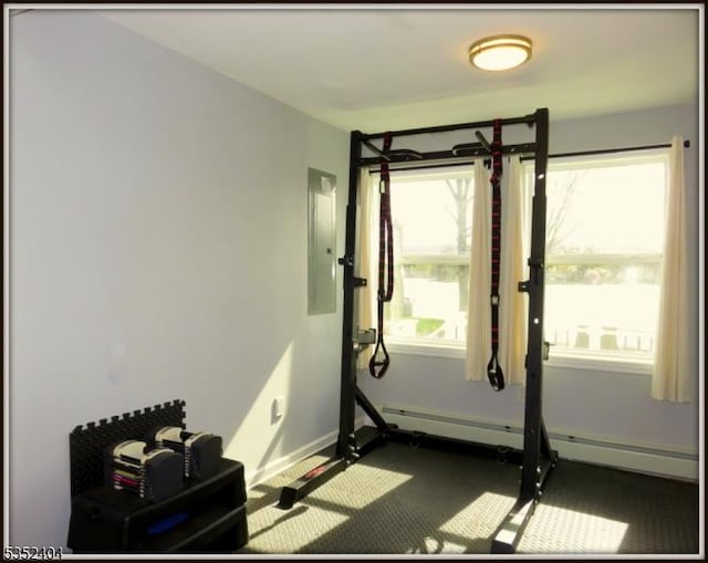 exercise area featuring carpet floors, baseboards, a baseboard heating unit, and electric panel