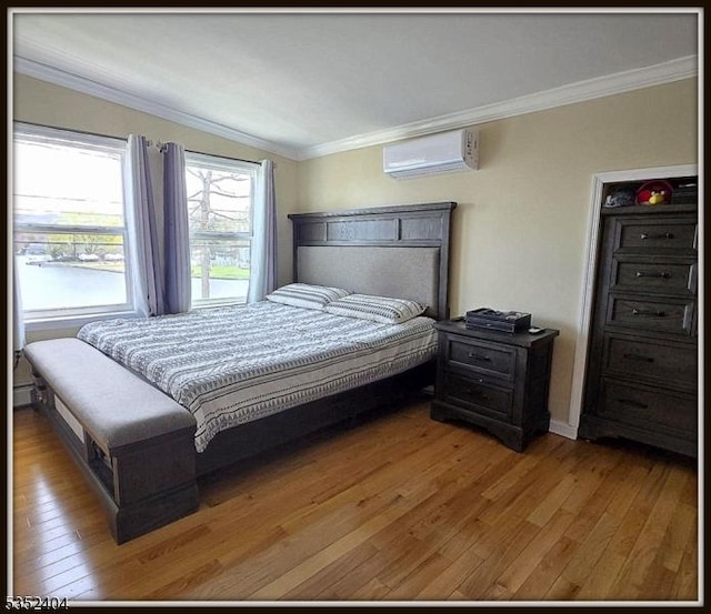 bedroom featuring crown molding, hardwood / wood-style flooring, and a wall mounted air conditioner