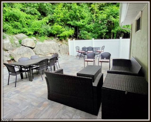 view of patio featuring outdoor dining area and fence