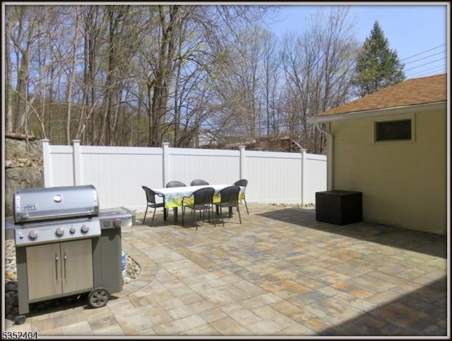 view of patio featuring outdoor dining area, fence, and area for grilling