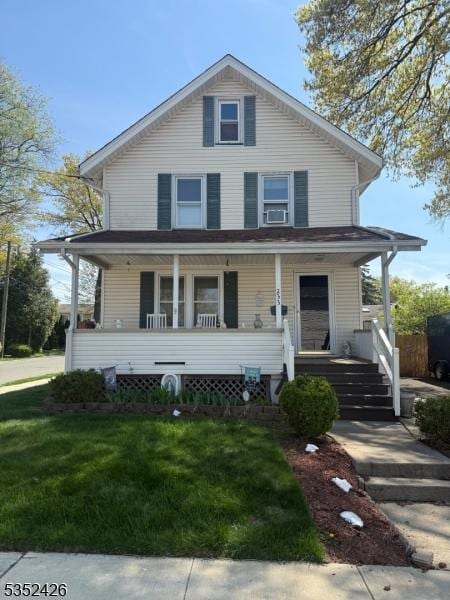 american foursquare style home featuring covered porch and a front yard