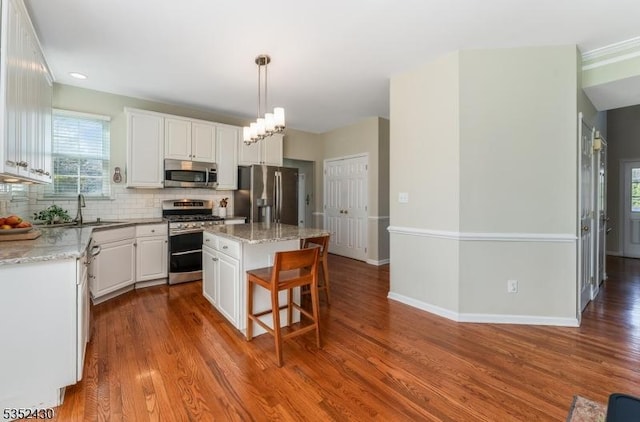 kitchen featuring a sink, dark wood-style flooring, plenty of natural light, white cabinetry, and appliances with stainless steel finishes