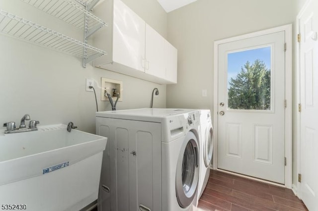 laundry area with independent washer and dryer, a sink, dark wood-type flooring, and cabinet space